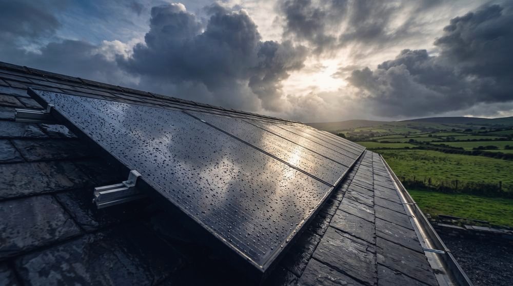 Solar panels on a slate roof under a stormy sky